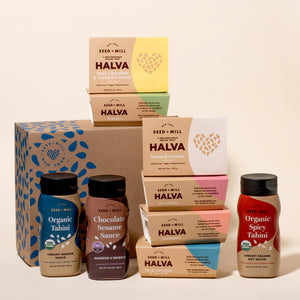 Assorted Seed + Mill products including halva boxes and tahini bottles on a beige background