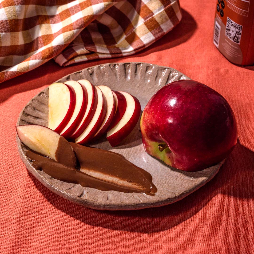Plate of sliced apples and a smear of chocolate sesame sauce
