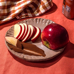 Plate of sliced apples and a smear of chocolate sesame sauce