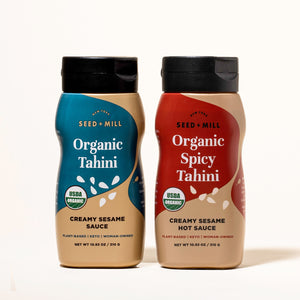 One bottle of Seed + Mill Organic Tahini  and one bottle of Seed + Mill organic spicy Tahini on a white background