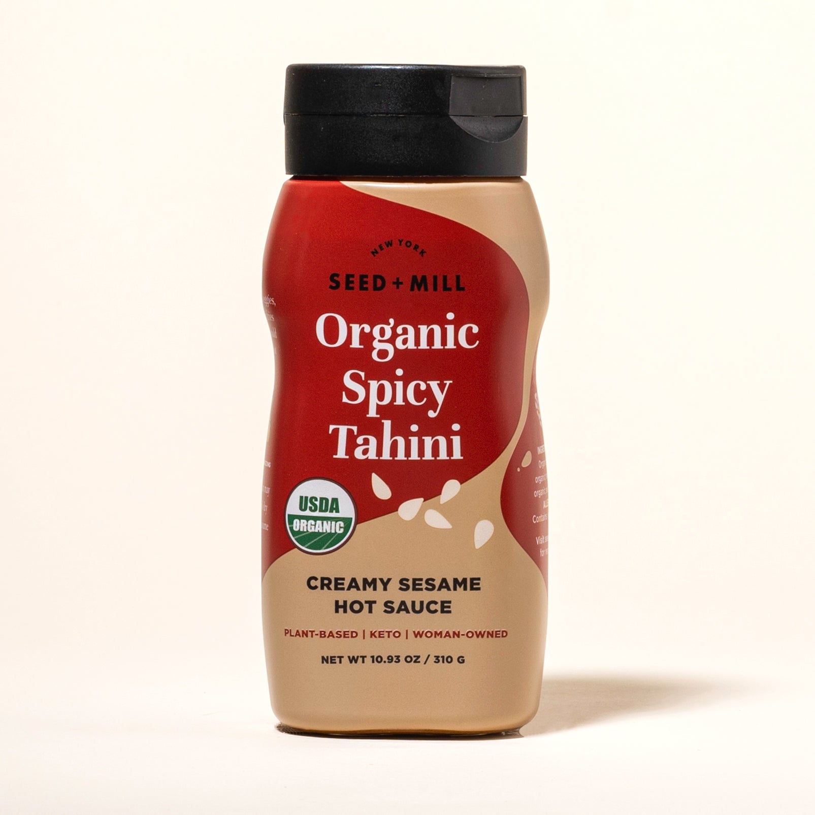Bottle of Seed + Mill Organic Spicy Tahini Hot Sauce on a white background