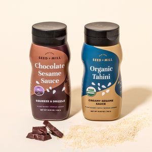 Two bottles of Seed + Mill products, Chocolate Sesame Sauce and Organic Tahini, on a beige background