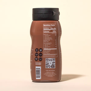 Back of a bottle of Seed + Mill chocolate sesame sauce with nutrition facts and QR code on a beige background